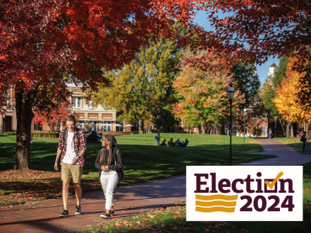 A fall scene at Elon University with two students walking and the Election 2024 mark